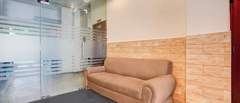 A reception area with a sofa, a glass door labeled 'RESTAURANT,' and a 'KITCHEN' sign.