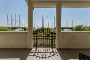 A gated entrance to a marina with sailboats docked in the background. - Holiday Home 'Sul Porto – Steps from the Sea' with Sea View, Private Terrace & AC (Grosseto)