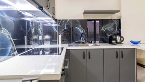 A modern kitchen with a central island, a built-in oven, and a sink. - Villa Verde (Aliko)