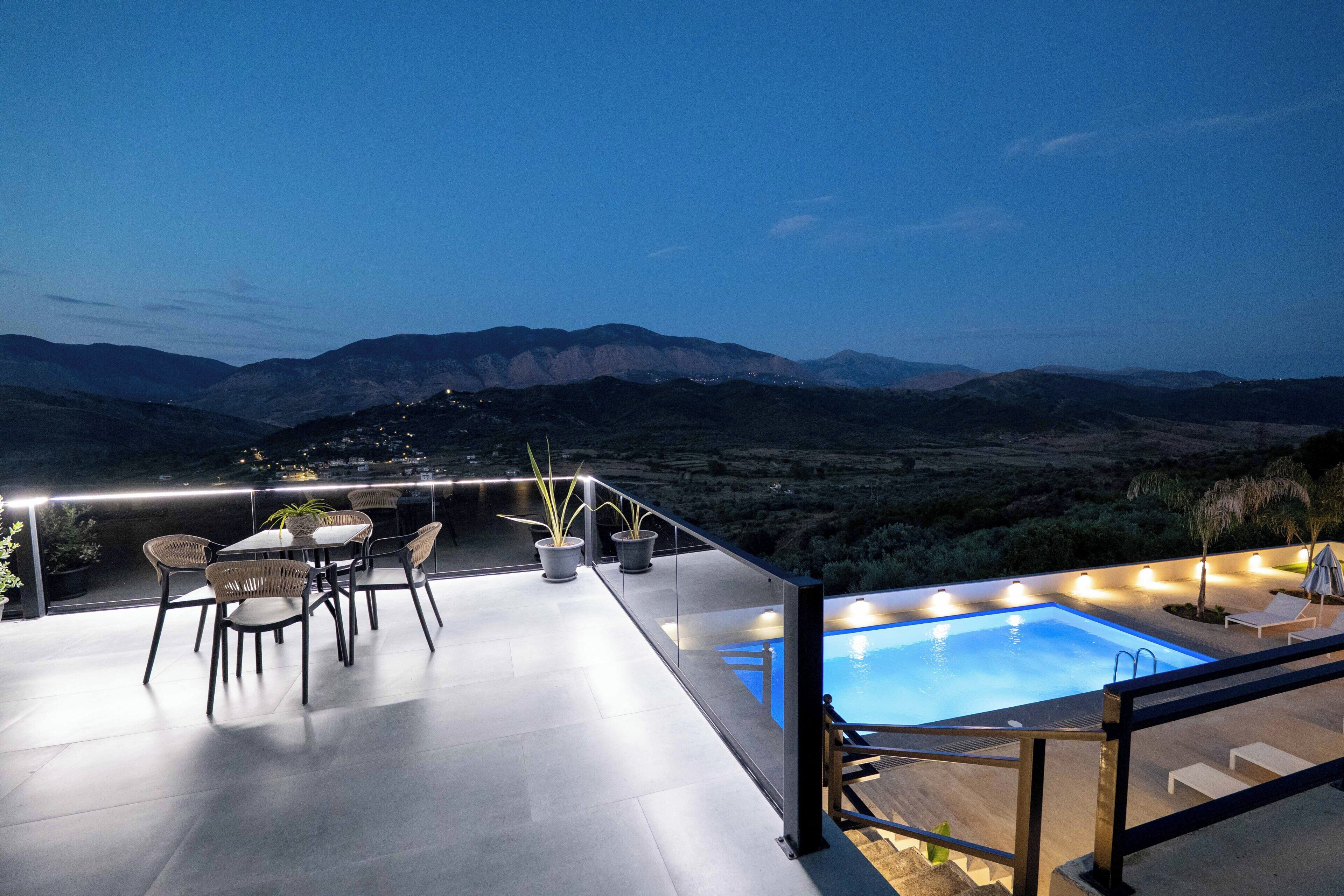 Una terraza en la azotea con piscina, sillas y plantas en macetas.