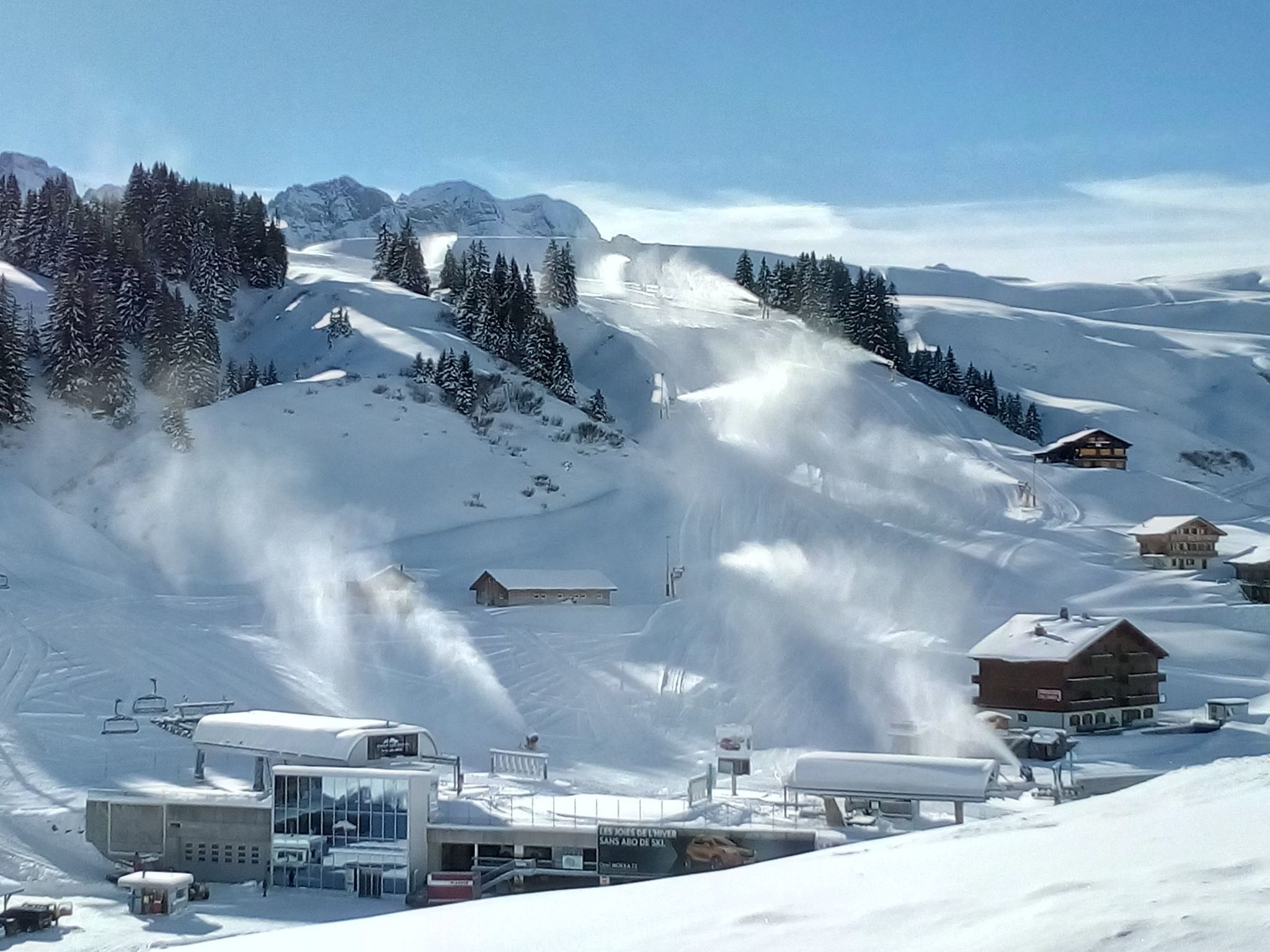 Une montagne enneigée, avec des remontées mécaniques et des bâtiments.