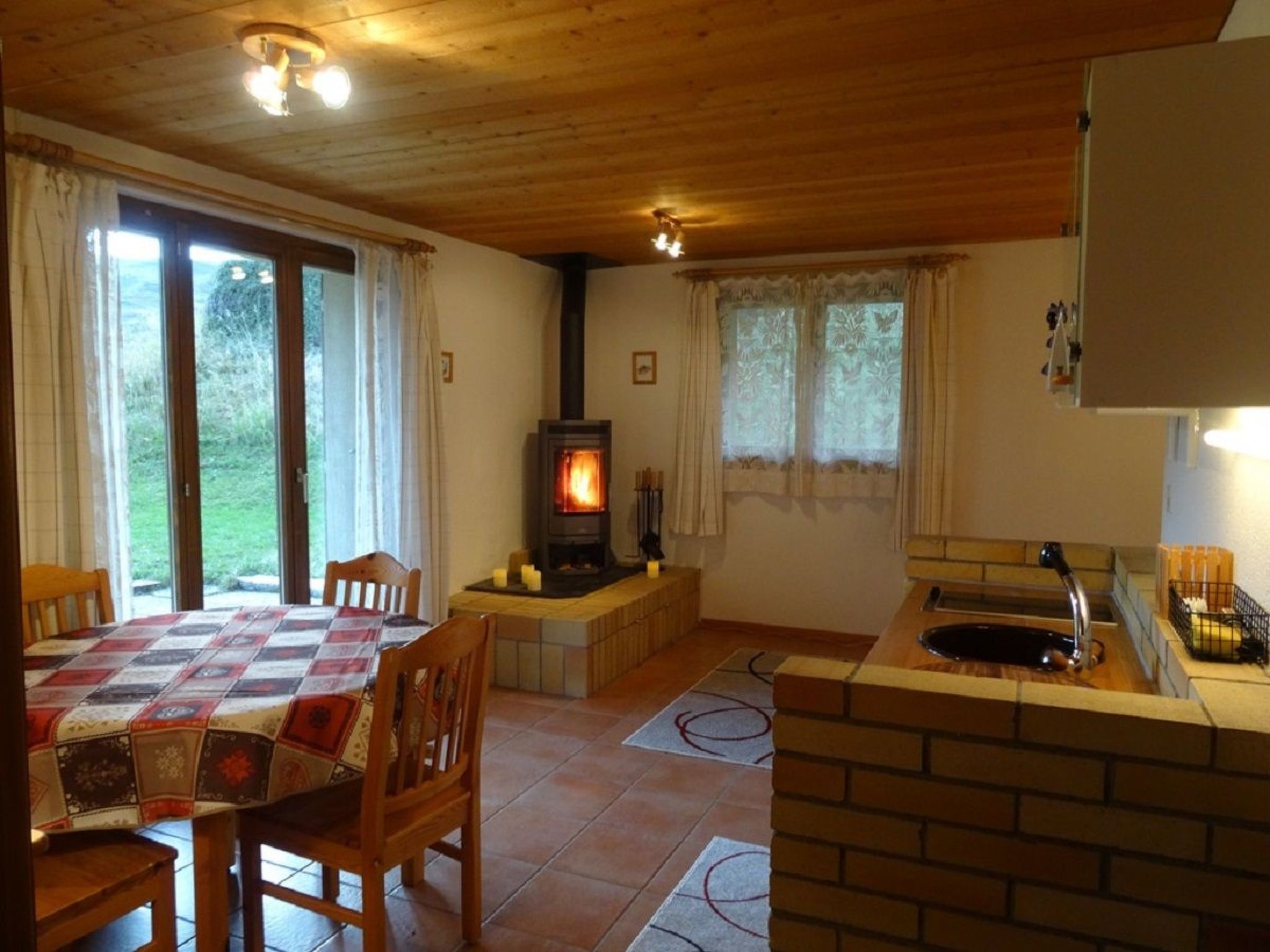 Ein gemütliches Zimmer mit Kamin, einem Esstisch und einer Küchenzeile.