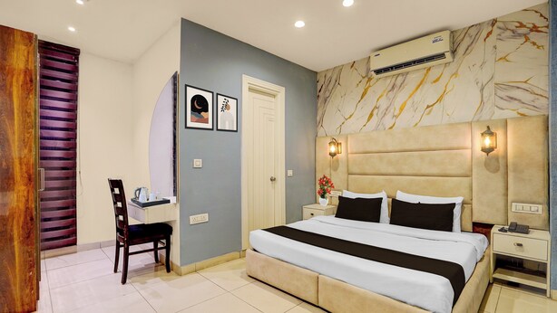 A bedroom with a bed, bedside tables, a desk, and a chair. - Townhouse Sector 20 Panchkula (Dera Bassi)