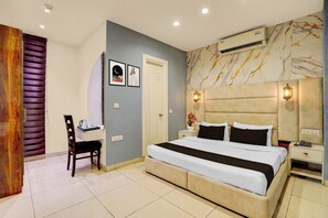 Un dormitorio con cama, mesitas de noche, un escritorio y una silla.