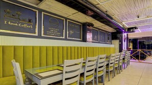 A restaurant interior with a long counter, cushioned booths, and wall decorations. - Townhouse Sector 20 Panchkula (Dera Bassi)