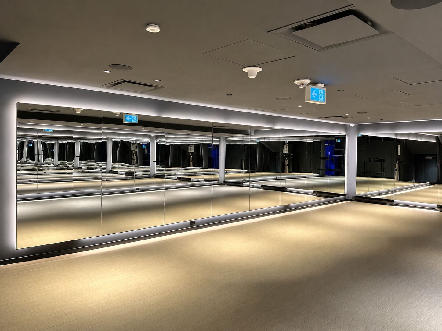 A modern, well-lit indoor space with reflective surfaces and directional signage.