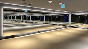 Um espaço interior moderno, bem iluminado, com superfícies refletoras e sinalização.