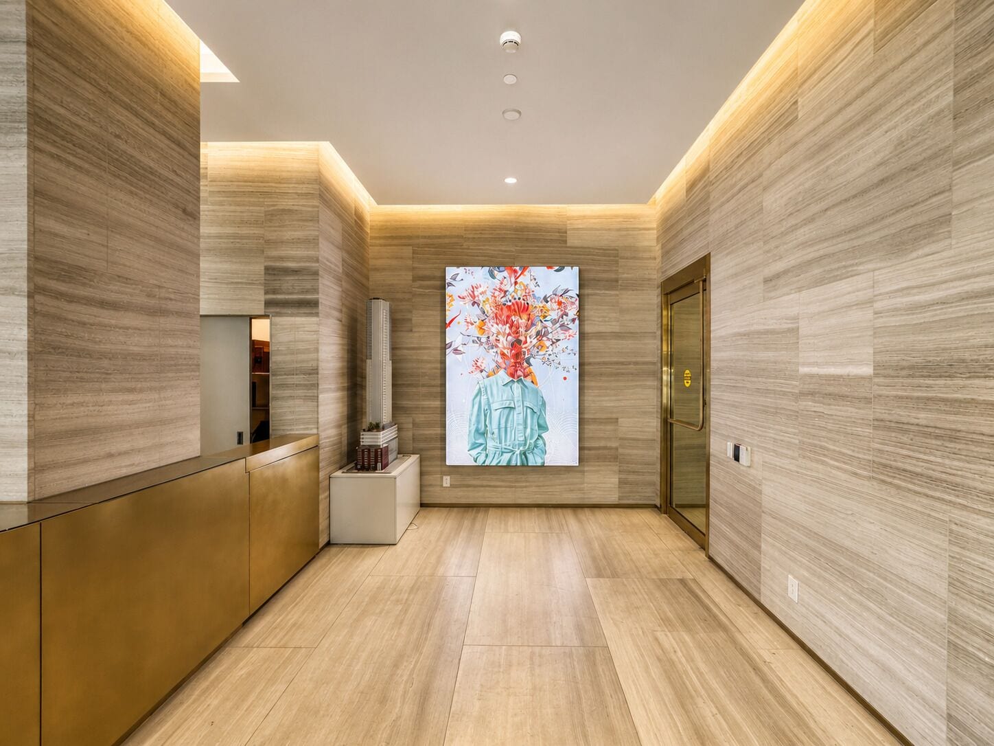 A modern lobby with a reception desk, a digital art display, and a door with a golden handle.