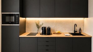 A modern kitchen with a built-in microwave, a coffee maker, and a sink. - Modern Elegance & Old-World Charm in the Most Iconic District – 623 (Budapest)