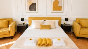 A hotel room with a large bed, two side tables, a sofa, and artwork on the walls. - Modern Elegance & Old-World Charm in the Most Iconic District – 623 (Budapest)