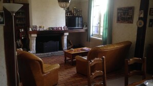 Ein traditionell eingerichtetes Wohnzimmer mit Kamin, Ledermöbeln und Bücherregal.