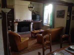 Ein traditionell eingerichtetes Wohnzimmer mit Kamin, Ledermöbeln und Bücherregal.