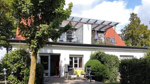 Et toetagers hus med en overdækket terrasse, garage og en velplejet have.