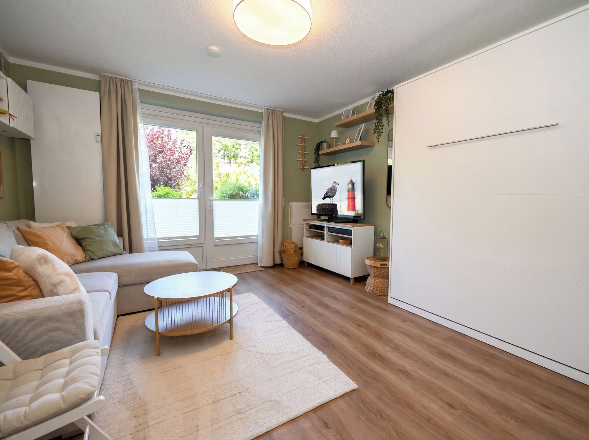 A modern living room with a sofa, a coffee table, a TV, and a white wardrobe.
