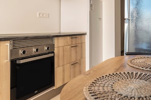 Eine moderne Küche mit Einbauofen, Holzschränken und einem Fenster mit Blick.