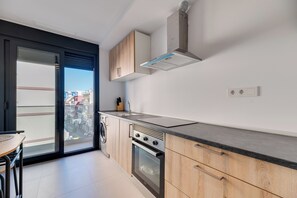 Eine moderne Küche mit Einbauofen, Spüle aus Edelstahl und Holzschränken.