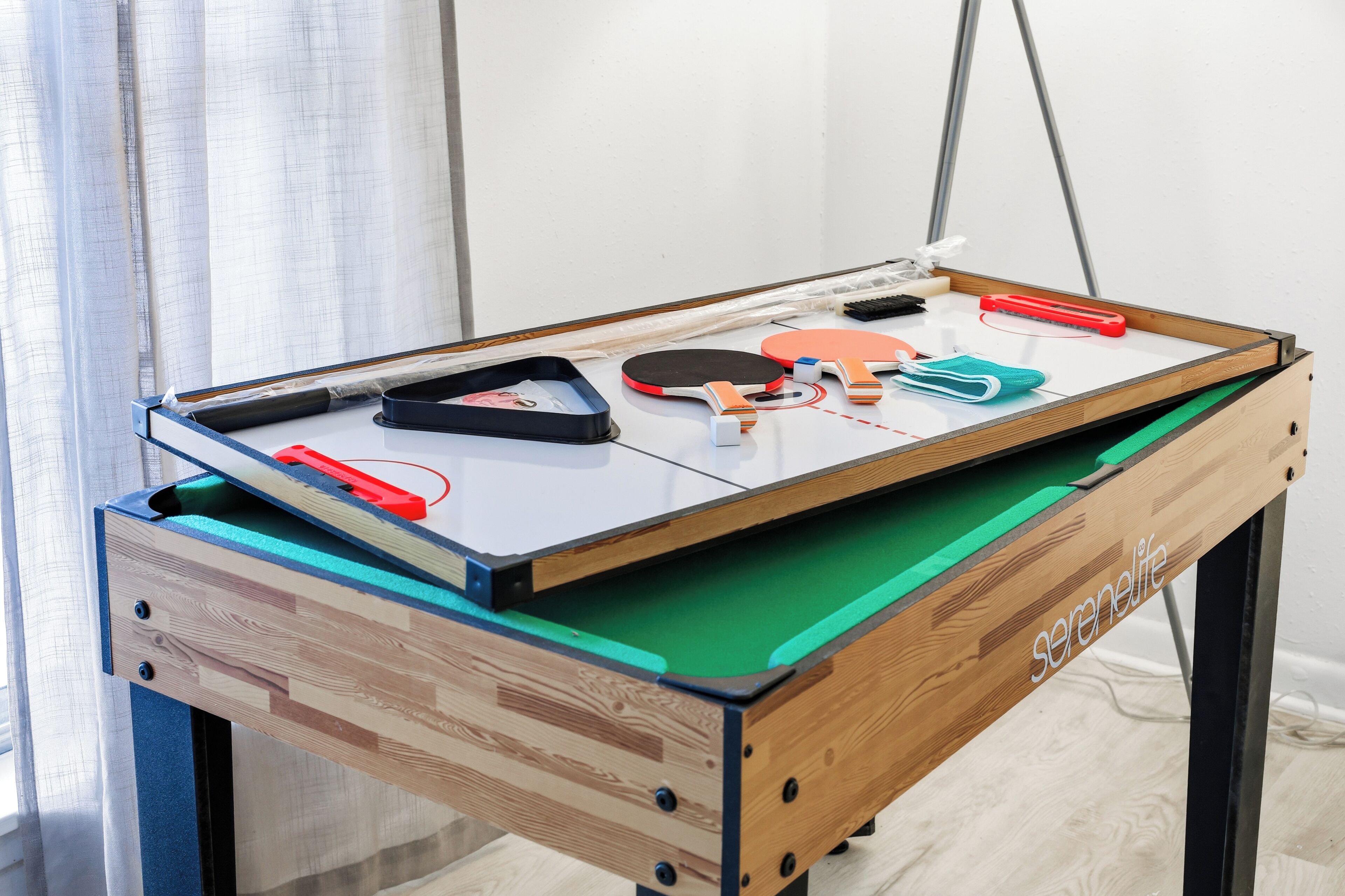 A pool table with various cues and a pocket.