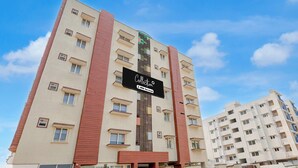 A multi-story residential building with a sign indicating it is serviced by OVO. - Collection O Atchutapuram (Visakhapatnam)