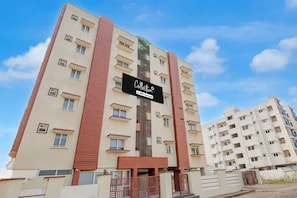 A multi-story residential building with a sign indicating it is serviced by OVO.