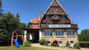 Edifici de dues plantes amb un cartell que diu "HOTEL ROSENHOF".