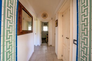 A hallway with a tiled floor, a mirror on the left, and a door on the right. - Casa Serena: with Pine Forest, Jacuzzi Tub & BBQ near the beach, Pet Friendly (San Vito dei Normanni)