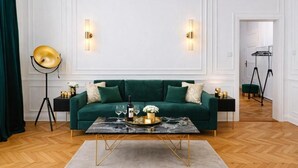 A room with a green sofa, a marble coffee table, and a floor lamp. - Luxury Riverside Hideaway w/ Panoramic Views & Top Amenities – 622 (Budapest)