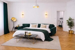Ein Hotelzimmer mit Bett, Nachttisch, Lampe und einer Topfpflanze.