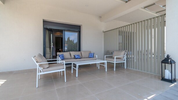 A patio with a sofa set, a coffee table, and a chair. - Sani Astera Deluxe by Rentals Pro - Sani Halkidiki (Sani)