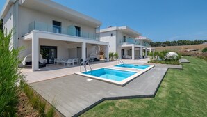 A modern two-story house with a swimming pool, outdoor seating, and a well-maintained lawn. - Sani Astera Deluxe by Rentals Pro - Sani Halkidiki (Sani)