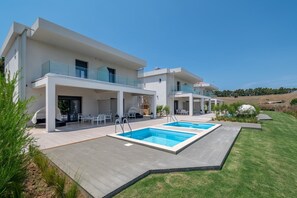 A modern two-story house with a swimming pool, outdoor seating, and a well-maintained lawn. - Sani Astera Deluxe by Rentals Pro - Sani Halkidiki (Sani)