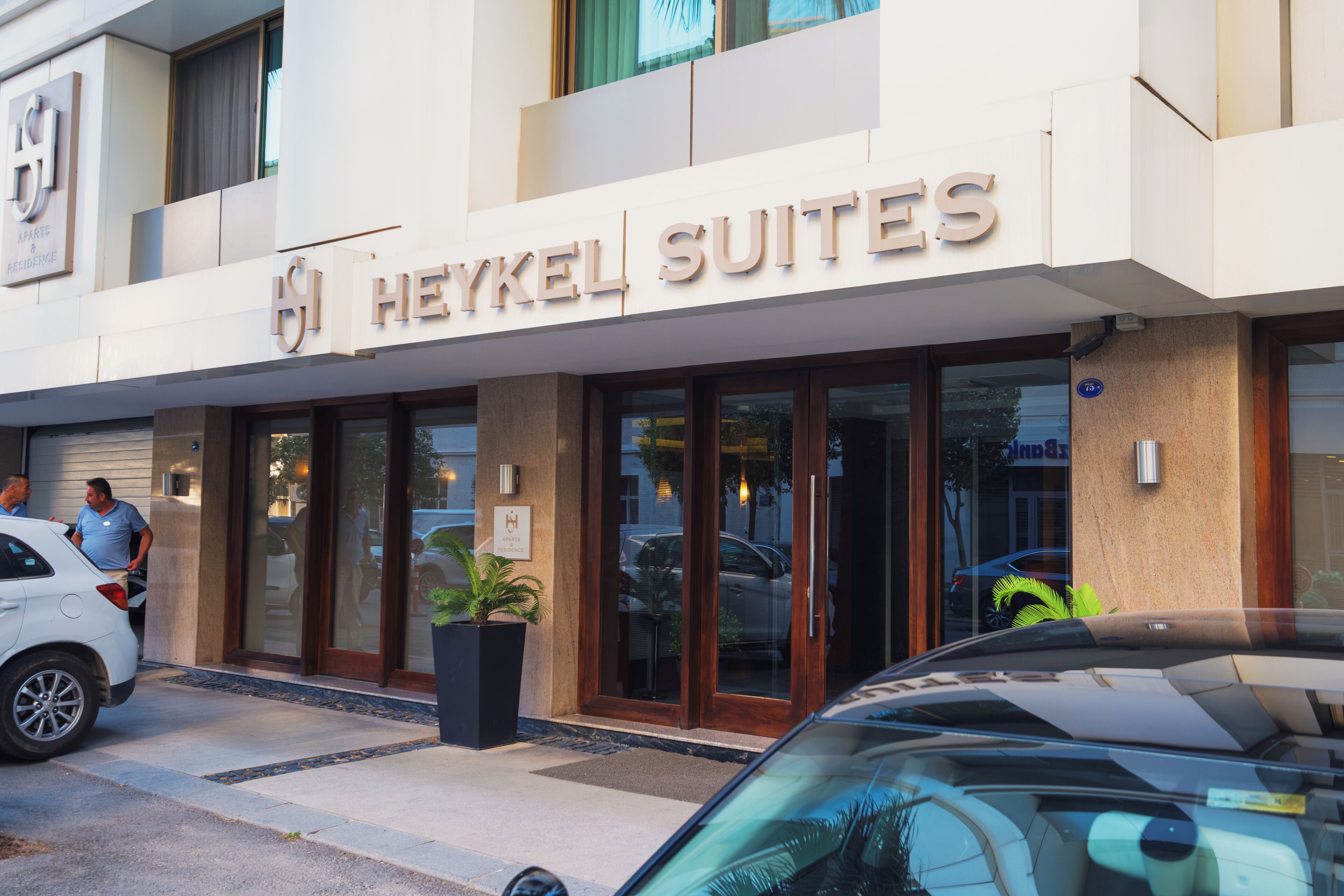 A hotel entrance with a sign reading 'Heykel Suites.'