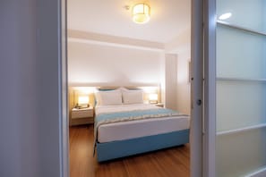 A bedroom with a bed, bedside lamps, and a nightstand.