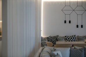 Ein modernes Wohnzimmer mit einer Couch, einem Couchtisch und einem gemusterten Teppich.