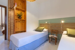 A bedroom with two beds, a wooden wardrobe, a chair, and a bedside table. - Villa Grazia – Your relaxing escape just steps from the sea 🌿☀️ (Santa Margherita di Pula)