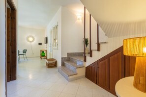 Eine Treppe mit Holzwändern, einer Lampe und einer Wandleuchte.