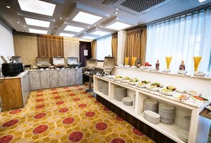 A hotel room with a breakfast bar, multiple seating options, and a view of the outdoors. - Unique Regency Hotel (Dhaka)
