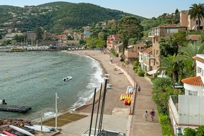 A coastal town with a beach, boats, and buildings.