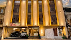 A hotel with a modern facade, multiple vertical windows, and a sign indicating it's the Agrawal Inn. - Hotel Agrawal Inn (Ujjain)