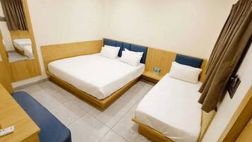 A hotel room with two beds, a desk, and a mirror.