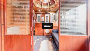 Una zona de recepción con interior de madera, un mostrador de recepción y un cartel que indica que es una casa de campo con servicios de empresa.