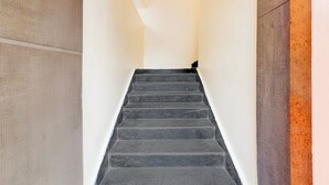 Una escalera con una pared texturizada a un lado y una pared lisa al otro.