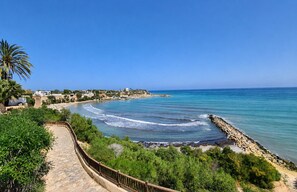 A coastal walkway with a stone path, a rocky breakwater, and a clear view of the sea. - Casa Cabo Roig, a 2-minute walk from Cabo Roig Beach (VC)