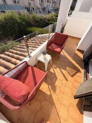 A rooftop terrace with wicker furniture, a small table, and a potted plant. - Casa Cabo Roig, a 2-minute walk from Cabo Roig Beach (VC)