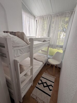 A bunk bed room with a window, a chair, and a rug. - Casa Cabo Roig, a 2-minute walk from Cabo Roig Beach (VC)