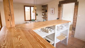A kitchen with a wooden countertop, white cabinets, and a hanging light fixture. - Quiet cottage with a terrace, 3 minutes from Albi (Castelnau-de-Lévis)