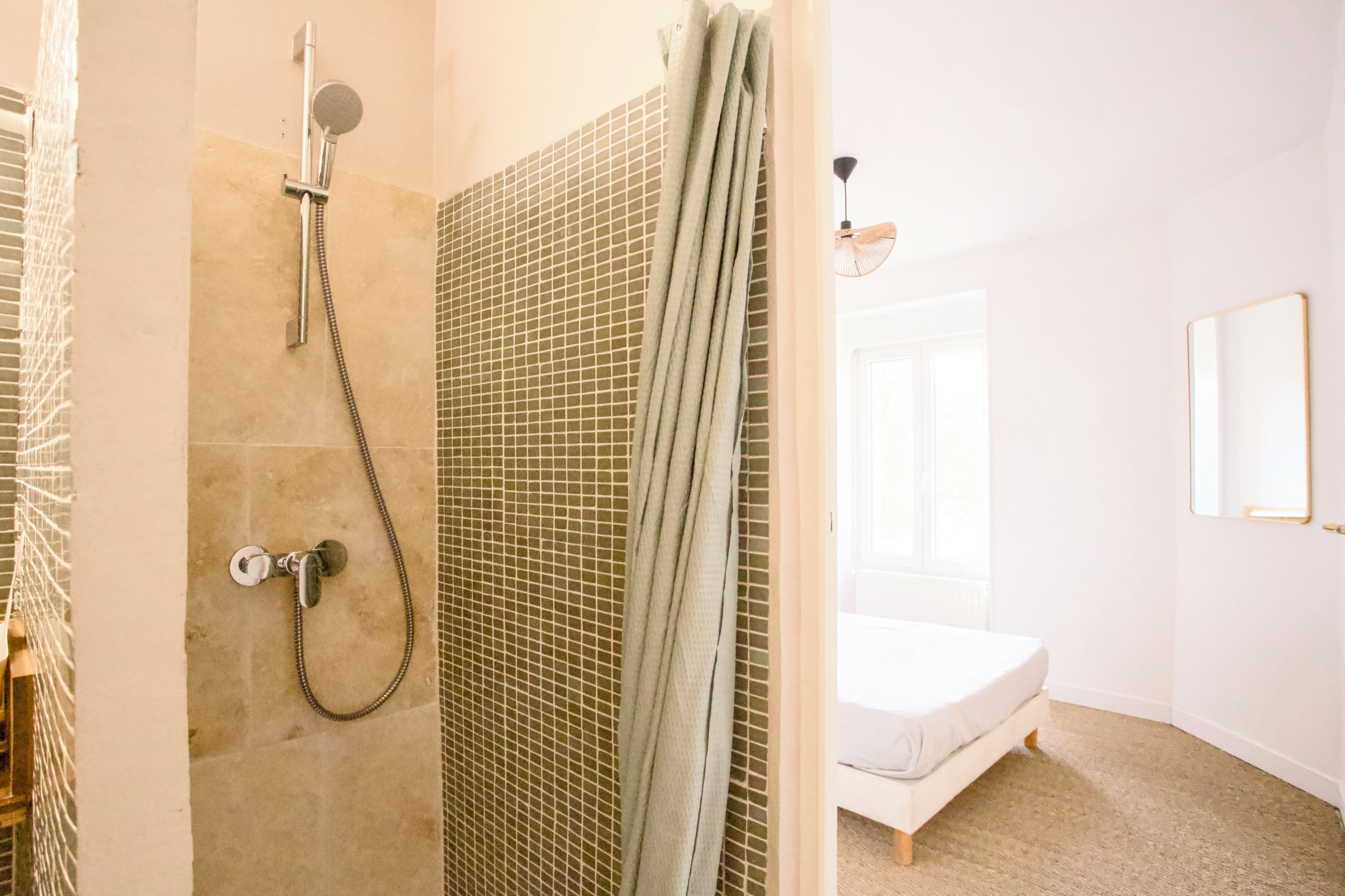 Une salle de bain avec une douche, des toilettes et un lit.