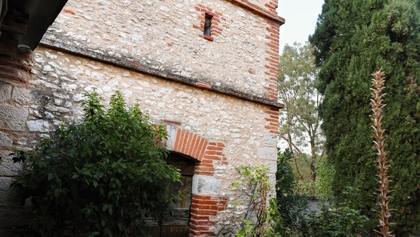 A stone building with a tiled roof, a narrow entrance, and a tall tree in the background. - Quiet cottage with a terrace, 3 minutes from Albi (Castelnau-de-Lévis)