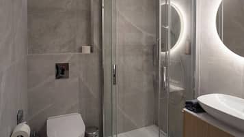 Une salle de bain moderne avec une douche à parois de verre, des toilettes et un lavabo avec un miroir.