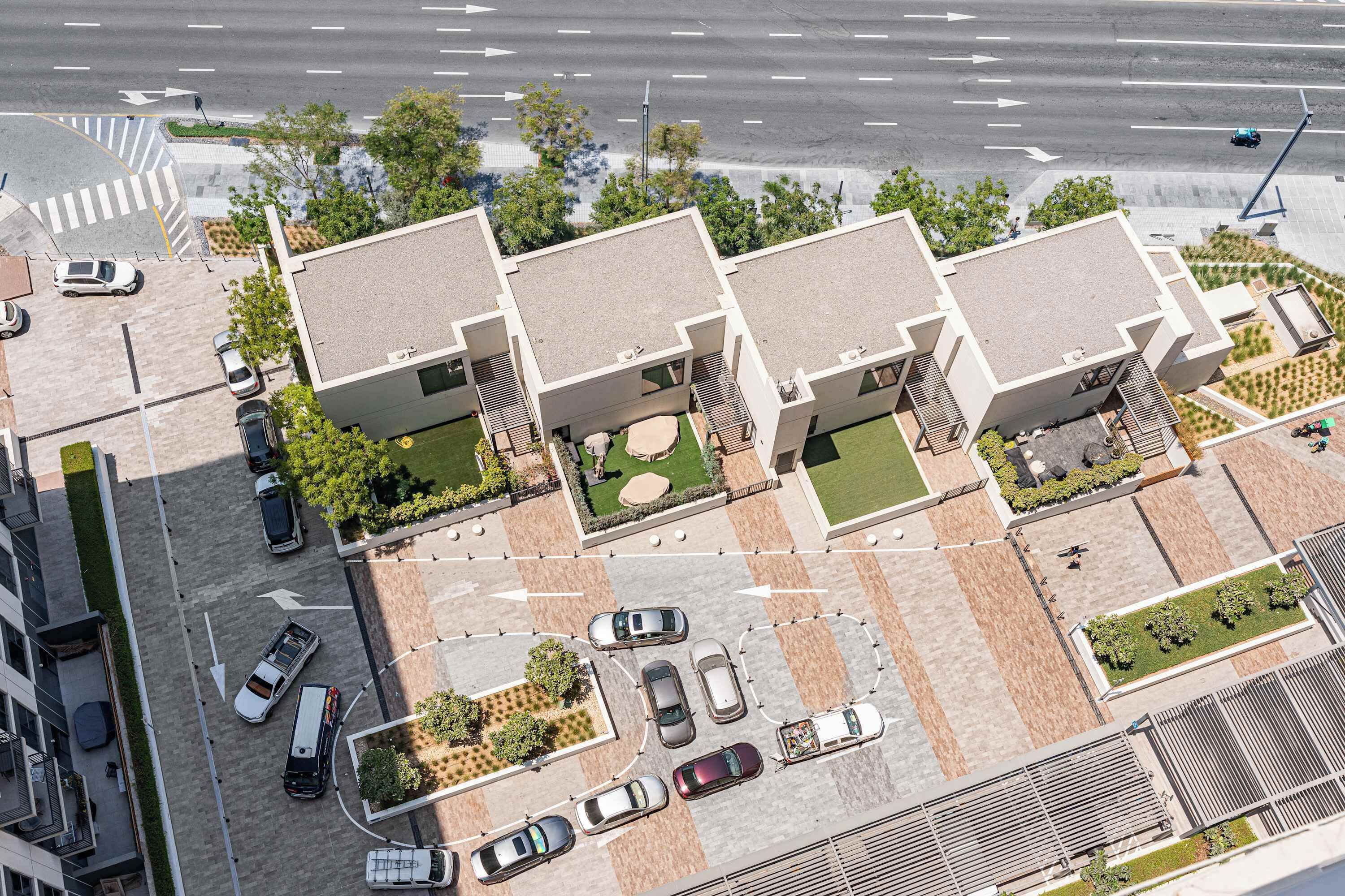 A modern building with a parking area and a road with directional arrows.