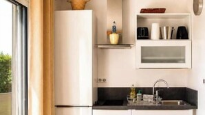 A modern kitchen with a built-in refrigerator, a sink, and a window. - La Terrasse Étoilée: Vacation rental attached to the owners' home, 1 bedroom, 4 (Saint-Médard-d'Excideuil)